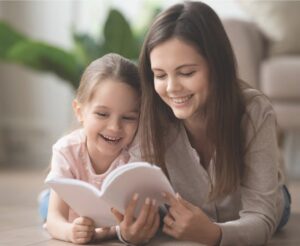 Nanny reading book with little girl